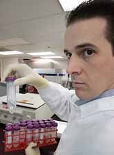 En expert i USA visar ett DNA-prov. Döda människor kan identifieras med hjälp av proven. Men det finns problem. DNA-prov från Thailand möglar. Foto: George Frey/PrB.