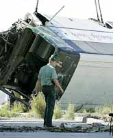 En spansk polis står vid den välta bussen. Tre personer dog vid olyckan på ön Teneriffa. Foto: Ramon de la Rocha/Pressens Bild