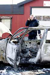 En polis undersöker en av rånarnas bilar. Rånarna eldade upp dem för att förstöra alla spår. Foto: Björn Larsson Rosvall/PrB