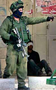 En israelisk soldat framför en gripen palestinier. Foto: Pressens Bild