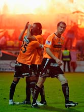 Gais spelare jublar efter sitt mål. Hammarbys supportrar har startat bråket på läktaren. Foto: Fredrik Landgren/Scanpix