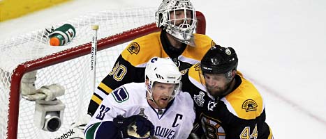 Henrik Sedin kämpar framför målet mot Bostons Dannis Seidenberg. Foto: Jonathan Hayward/Scanpix