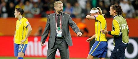 Förbundskaptenen Thomas Dennerby tröstar ledsna svenska spelare efter förlusten. FOTO: Matthias Schrader/Scanpix