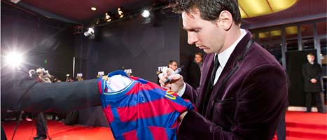 Lionel Messi skriver sin autograf på en tröja före prisutdelningen. FOTO: Alessandro Della Bella/SCANPIX