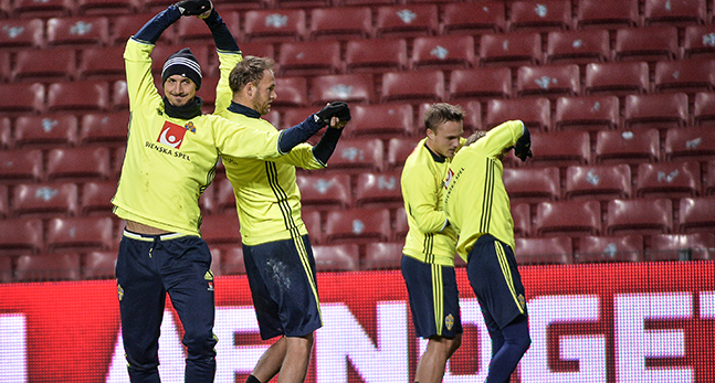 Fotbollsspelare gör rörelser för att värma upp