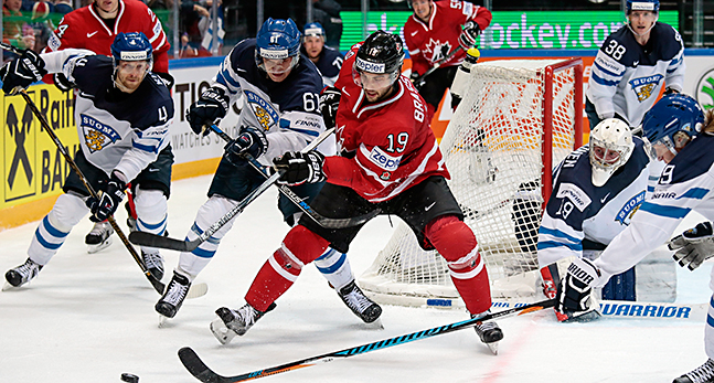 Två spelare från Kanada respektive Finland slåss om pucken vid Finlands målbur.
