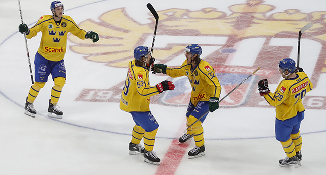 Fyra spelare i Tre Kronor jublar på isen.