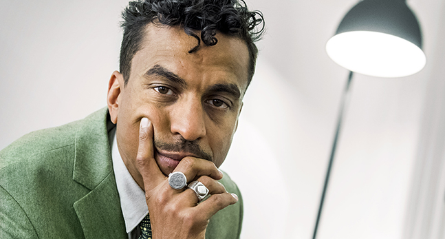 Timbuktu tittar in i kameran. Han stödjer sig med handen mot hakan.