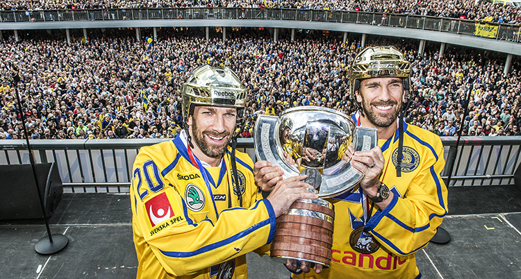 Bröderna Joel och Henrik Lundqvist håller i pokalen med massor av människor bakom.