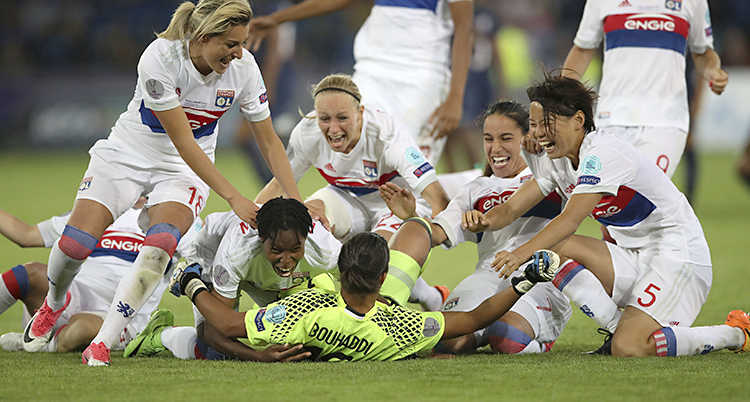 Flera fotbollsspelare i Lyon kastar sig över varandra på fotbollsplanen för att kramas. Underst ligger målvakten.
