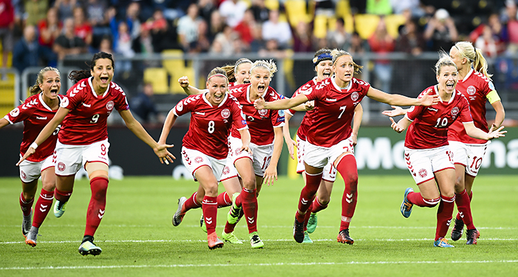 Röd och vit-klädda fotbollsspelare springer på planen och ser glada ut efter vinsten mot Österrike.