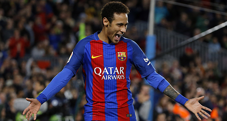 Neymar i Barcelonas rödblå-randiga tröja står på fotbollsplanen och ser glad ut. Han slår ut med händerna.