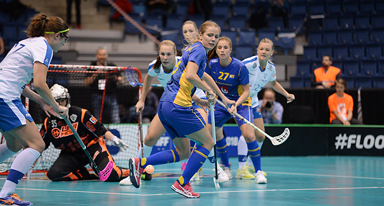 En matchbild på flera spelare med sina innebandyklubbor.