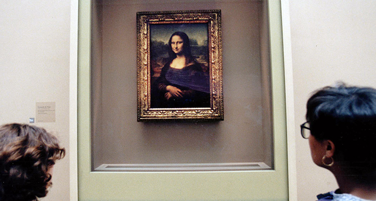 En bild på tavlan Mona-Lisa. Ramen är av guld. Bilden är mörk förutom Mona-Lisas ljusa ansikte och händer som hon har korsat över midjan.