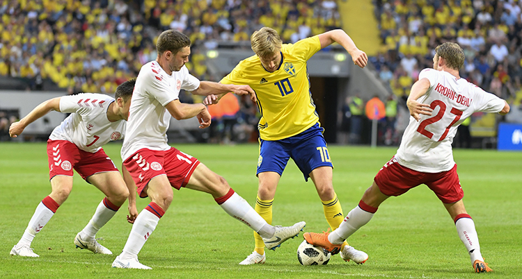 Emil Forsberg med tre danska spelare i matchen mot Danmark.
