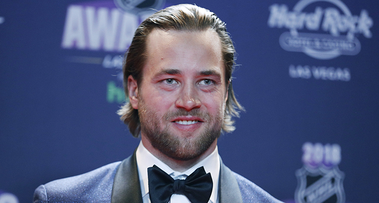 Victor Hedman finklädd i kostym med fluga ler på prisceremonin.
