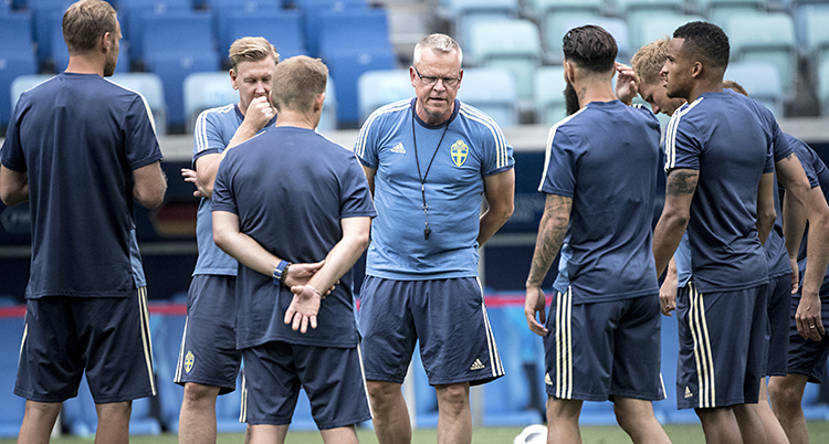 Janne Andersson har samlat spelarna på träning. Alla har blå träningskläder.