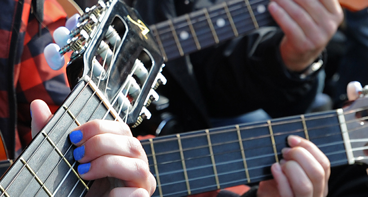Folk som spelar gitarr.