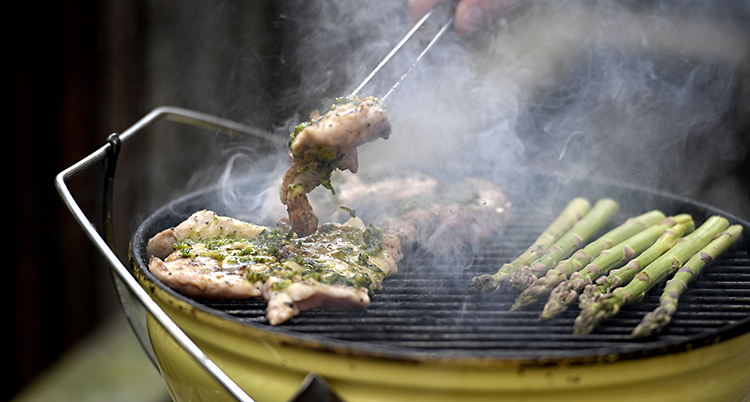 En man grillar.