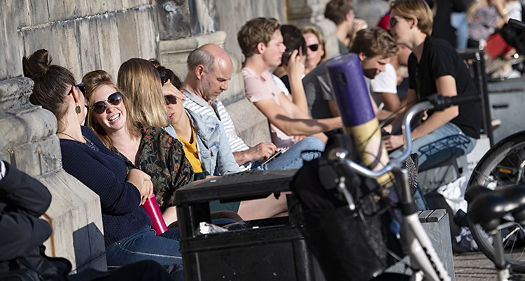 Folk njuter av sol och värme