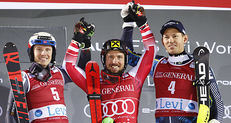 André Myhrer på prispallen tillsammans med ettan och tvåan i loppet. De håller varandra i händerna och höjer armarna i luften.
