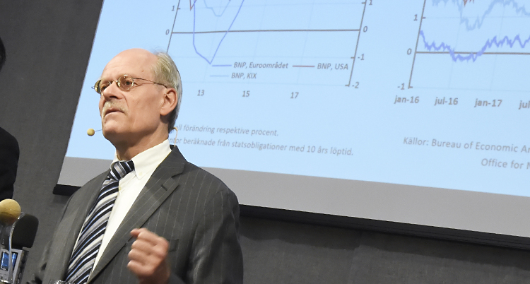 Stefan Ingves framför en bild med tabeller