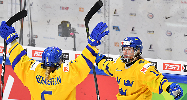 Två av spelarna sträcker ut armarna mot varandra efter ett mål.