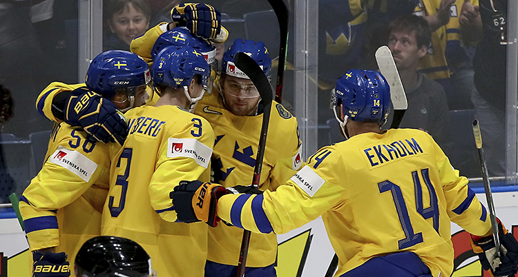 En bild på flera spelare i gult som kramas.