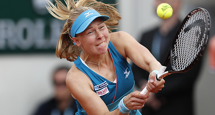 Johanna Larsson slår en boll med sitt racket.
