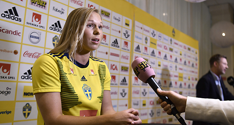 Jonna blir intervjuad. En hand med en mikrofon sträcks fram mot henne.