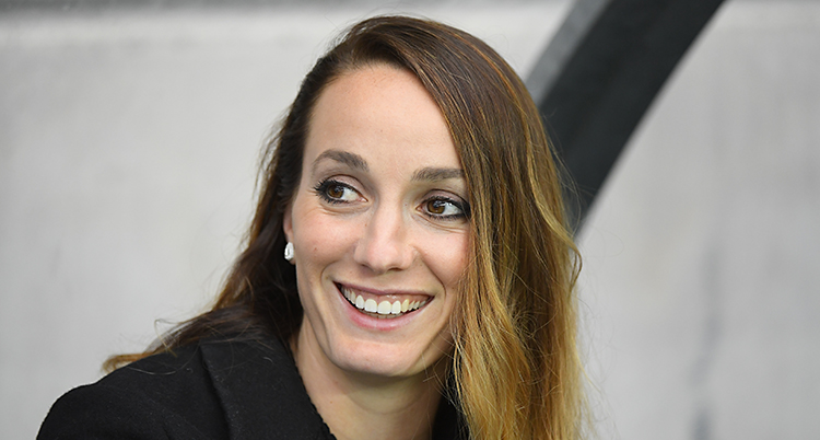 Fotbollsspelaren Kosovare Asllani ler och tittar åt sidan. Hon har en svart tröja på sig.