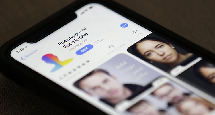 En mobiltelefon. På skärmen syns att någon ska ladda ner appen Faceapp.