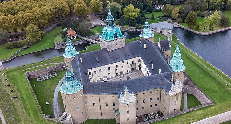 Flygbild över slottet. Det ligger på en ö och har flera torn och är byggt i fyrkant med innegård.