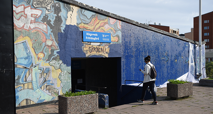 En mur till häften med graffitti och till hälften målad blå