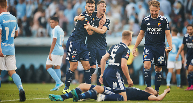 Djurgårdens spelare kramar om varandra. Några står, några ligger på gräset.