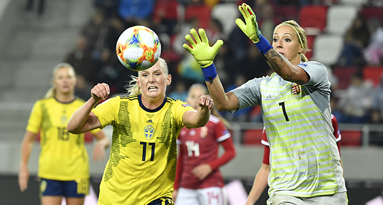 Två fotbollspelare närmar sig en fotboll som är i luften.