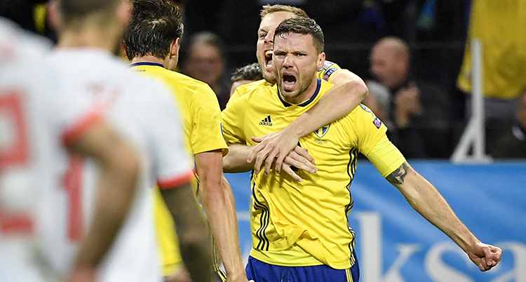 Marcus Berg jublar. En annan spelare kramar om honom bakifrån.