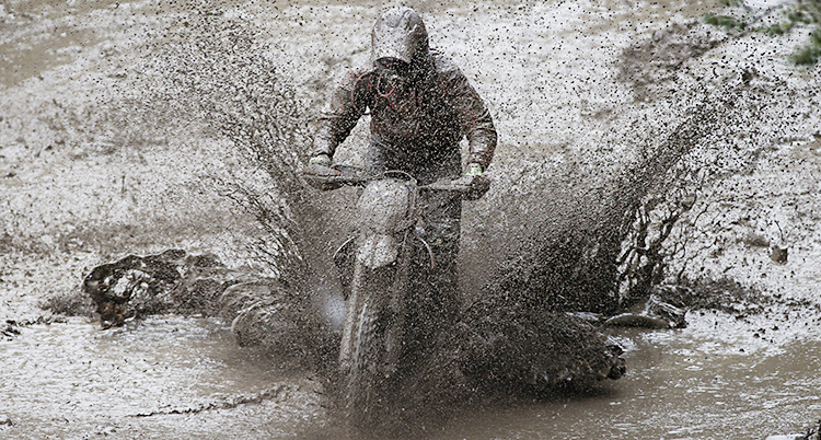 En motorcykel kör genom lera