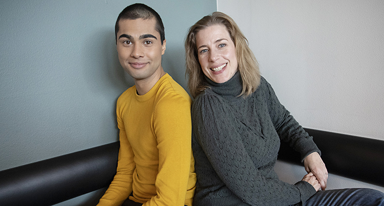 En unga kille i gul tröja sitter bredvid en lite äldre kvinna i grå polo