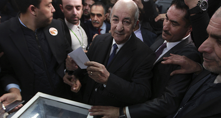 Abdelmadjid Tebboune blir ny president i Algeriet. Han håller ett röstkort i handen.