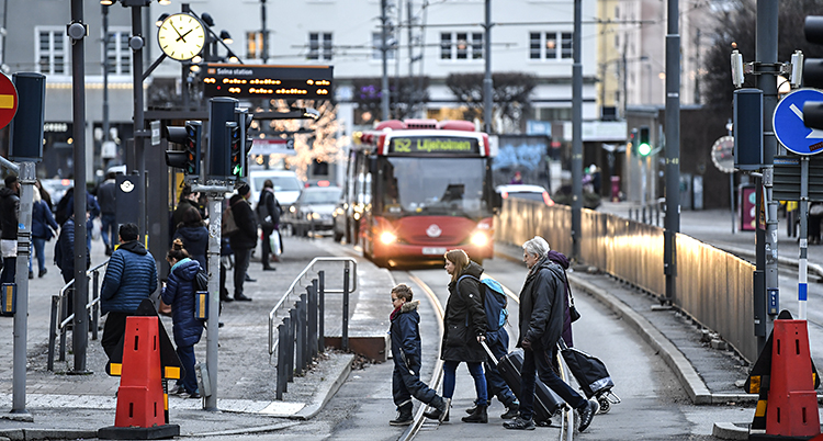 En bild som visar centrum i Sundbyberg. En familj korsar en väg. En buss kommer i bakgrunden.