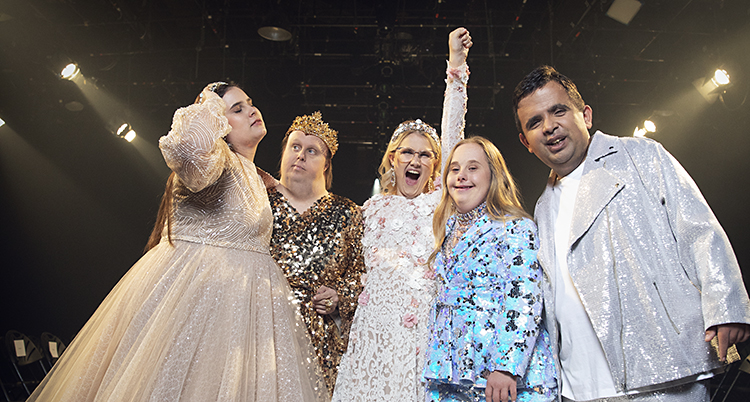 Kitty, Nicklas, Emma, Ida och Alex står på en catwalk. De har på sig kläder som glittrar.