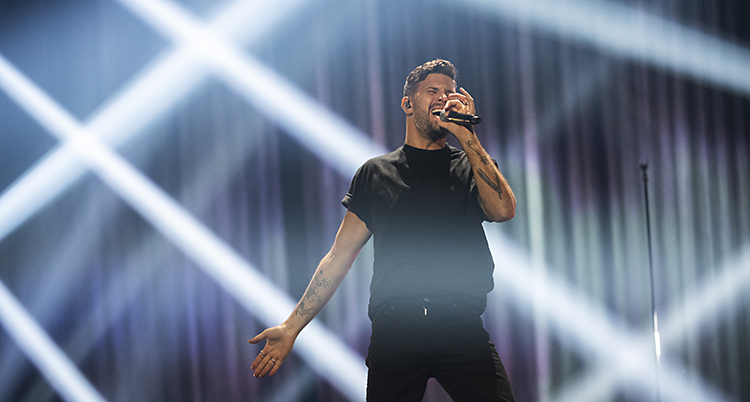 Robin Bengtsson står på scenen i Linköping. Han tar i och sjunger i en mikrofon.