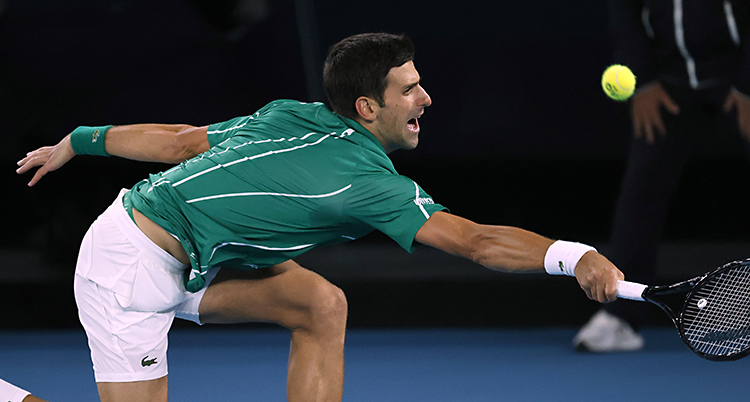 Djokovic sträcker sig efter en boll med racketen.