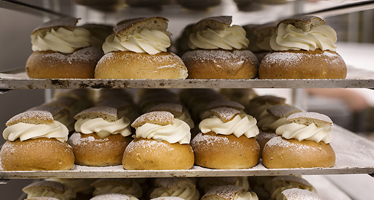 Bild på flera plåtar med många semlor.