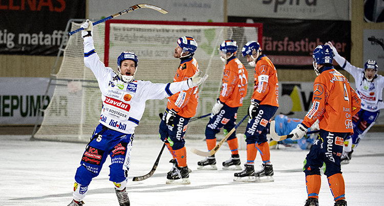 Han håller upp klubban och ser glad ut