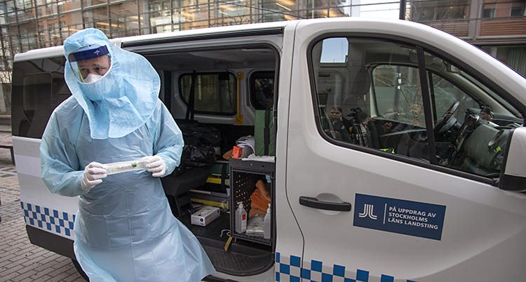Han står bredvid en ambulans.