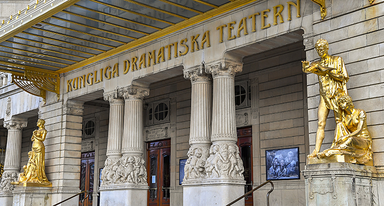 En bild på Dramatens framsida. Byggnaden är gammal. Den har guldfärgade statyer på sidorna.