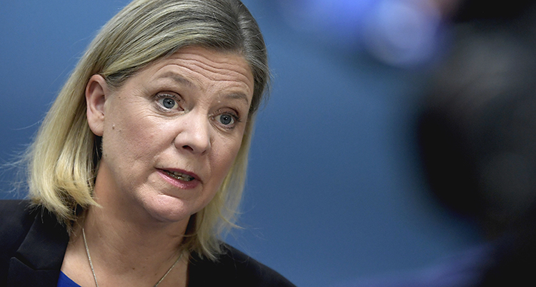 Hon har ljust hår till axlarna och ser allvarlig ut