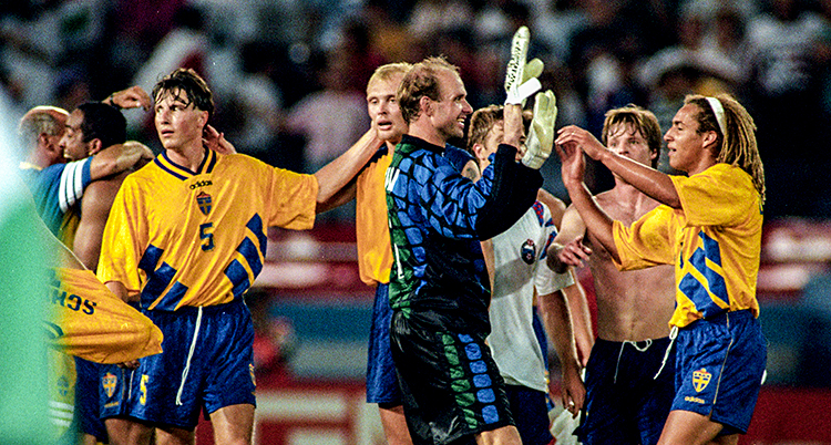 Bilden är från en match i fotboll. Matchen är slut. Sveriges spelare jublar tillsammans.